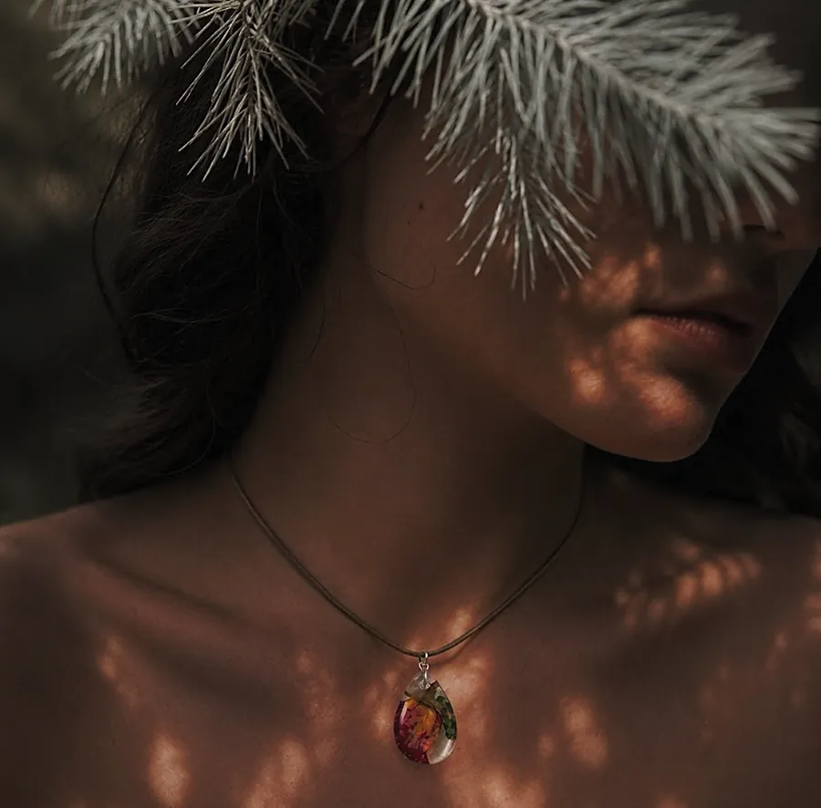 Collana Promessa indossata all'ombra di un ramo di pino